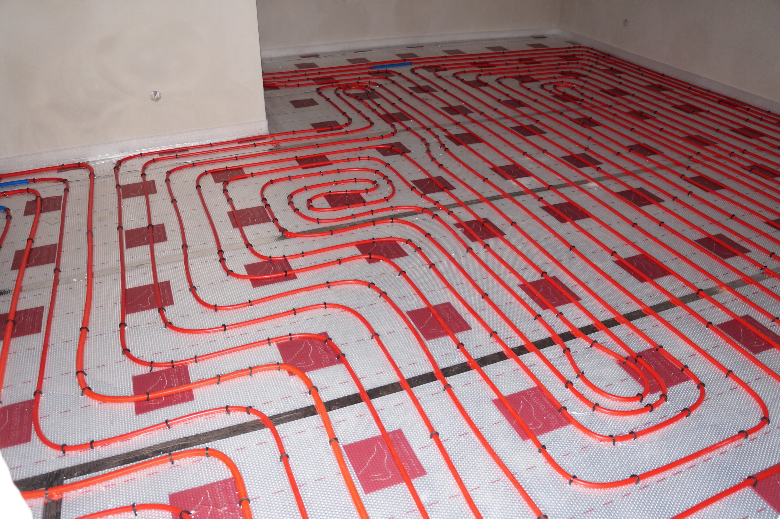 "Underfloor heating pipes laid in loops on an insulated floor"